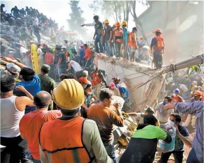  ??  ?? Decenas de personas participar­on en las labores de rescate en los inmuebles colapsados.