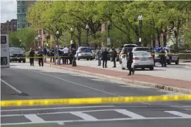  ?? NICOLAuS CzARnECkI / HERALD STAFF ?? NO INJURIES: Boston police probe a daylight shootout along Massachuse­tts Avenue on Saturday afternoon.