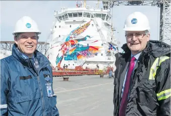  ?? PAUL CHIASSON/THE CANADIAN PRESS ?? Seaway CEO Terence Bowles, left, and Minister of Transport Marc Garneau stand next to the CSL St-Laurent during the opening of the navigation season on Monday in Montreal.