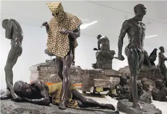  ?? THE ASSOCIATED PRESS ?? A sculpture called the Leopard Man, second from left, is stored with others in a cavernous room at the Africa Museum in Belgium. The museum is reopening today after a 10-year overhaul.