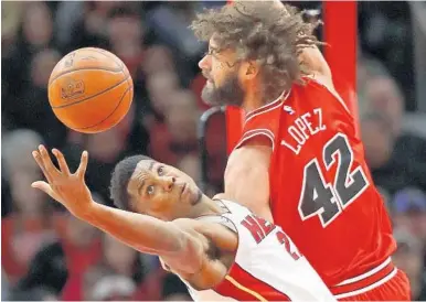  ?? JONATHAN DANIEL/GETTY IMAGES ?? Miami’s Hassan Whiteside reaches for a rebound against Chicago’s Robin Lopez during Monday afternoon’s game in Chicago. The Heat’s seven-game winning streak ended with the eight-point loss.