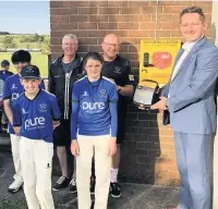  ??  ?? Stuart Maher (right) and members of Baxenden Cricket Club unveil the defibrilla­tor