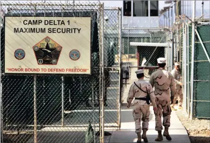  ?? PICTURES: AP ?? US military guards walk within Camp Delta military-run prison, at the Guantanamo Bay US Naval Base, Cuba. A draft executive order shows President Donald Trump asking for a review of America’s methods for interrogat­ion of terror suspects and whether to...