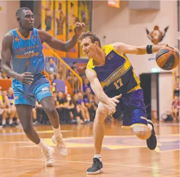  ?? Picture: ZAK SIMMONDS ?? SWEEP: Townsville Heat guard Peter Crawford attempts to drive past Marlins forward Kuany Kuany in game two of the QBL grand final series.