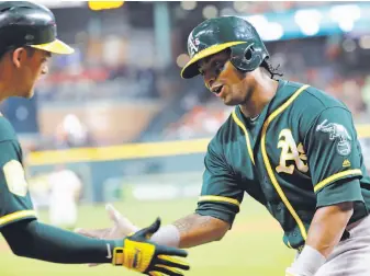  ?? David J. Phillip / Associated Press ?? The A’s with the big bats were Khris Davis (right), who hit a double and a triple and had three RBIs, and Chad Pinder, who went 2-for-3 with a homer, three RBIs and two walks.