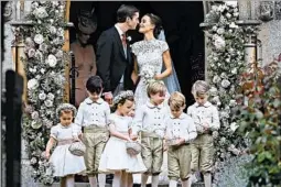  ?? JUSTIN TALLIS/GETTY-AFP ?? Pippa Middleton kisses new husband, James Matthews, after their wedding Saturday. Ahead of the couple are Princess Charlotte, left, and Prince George, second from right.