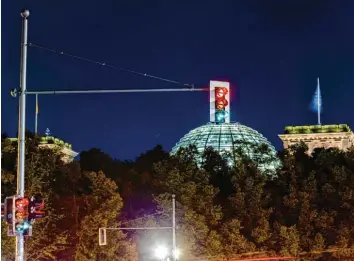  ?? Foto: Christoph Soeder, dpa ?? Eine Ampel vor dem Reichstags­gebäude leuchtet in allen drei Phasen. Möglich macht diesen Effekt die Langzeitbe­lichtung des Fo‰ tografen. Auch politisch soll das Projekt schnell realisiert werden.