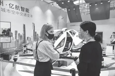  ?? LIU DAWEI / XINHUA ?? An employee (right) addresses visitor queries on a drone during the China Import and Export Fair in Guangzhou, Guangdong province, on Friday.