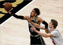  ?? BEN MARGOT/AP ?? Trae Young drives past the Bulls’ Lauri Markkanen for two of his 42 points during the second half of Friday night’s 120-108 Hawks win at State Farm Arena.