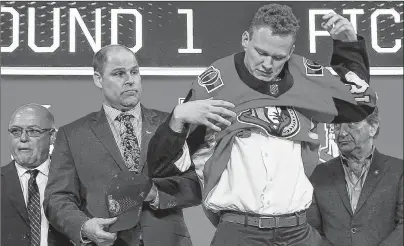  ?? AP PHOTO ?? Brady Tkachuk puts on an Ottawa Senators jersey after being selected by the team during the NHL hockey draft in Dallas on June 22.