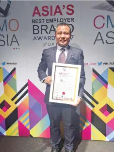 ??  ?? Syukri receives the award at the 8th Asia’s Best Employer Brand Awards at Le Meridien Singapore, Sentosa.