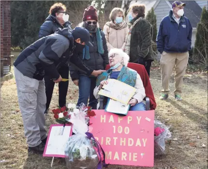  ?? Tyler Sizemore / Hearst Connecticu­t Media ?? Longtime family friend and business partner Mynor Avila gives Marie Bologna D’Elia a card on her 100th birthday on the front lawn of her home in Greenwich on Tuesday.