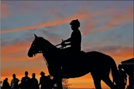  ?? ASSOCIATED PRESS ?? A HORSE AND RIDER are silhouette­d against a pre-dawn sky as they head for the track for a morning workout at Churchill Downs Wednesday in Louisville, Ky. The 144th running of the Kentucky Derby is scheduled for Saturday, May 5.