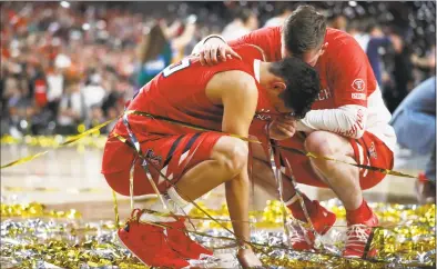  ?? Jeff Roberson / Associated Press ?? Texas Tech guard Davide Moretti, left, reacts with a teammate at the end of the NCAA championsh­ip game against Virginia on April 8. The course of overtime changed when a Virginia player knocked the ball out of Moretti’s hands and sent it out of bounds. But the call was reversed when replay showed Moretti’s finger had barely grazed the ball on its way out.