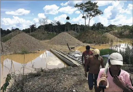  ?? The Associated Press/RODRIGO ABD ?? Illegal gold miners walk in a mining camp in Boca Colorado, part of Peru’s Madre de Dios province in the Amazon. It’s this forlorn corner of the Amazon that Pope Francis visited Jan. 19 amid what has been called a modern-day gold rush of illegal miners...