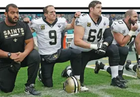  ?? AP ?? Defiant: Drew Brees (second left) kneels before the anthem