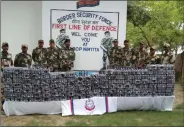  ??  ?? BSF jawans with the seized drugs at the South Bengal border.