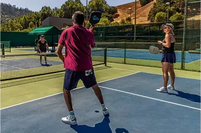  ?? PHOTOS BY CHRISTIE HEMM KLOK/THE NEW YORK TIMES ?? Nish Nadaraja, an entreprene­ur in Northern California, and his wife played pickleball against some of their friends at the Cañon Swim & Tennis Club in Fairfax, Calif.