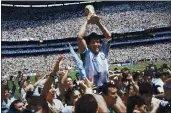  ?? CARLO FUMAGALLI — THE ASSOCIATED PRESS, FILE ?? Diego Maradona holds up his team’s trophy after Argentina’s 3-2 victory over West Germany at the 1986 World Cup final at Azteca Stadium in Mexico City.