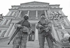  ?? PAUL SANCYA/AP, FILE ?? Armed men stand on the steps of the state Capitol after a rally in support of President Donald Trump on Jan. 6 in Lansing, Mich.