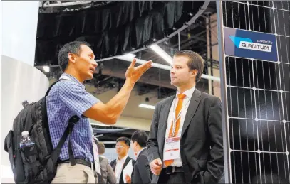  ?? Elizabeth Brumley ?? Las Vegas Review-journal Vu Lac of TE Connectivi­ty, left, talks with Max Schurad of Hannah Q Cells during the Solar Power Internatio­nal Expo on Monday.