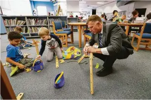 ??  ?? Principal Matthew Paulson of Ed White E-STEM Elementary joins students for makerspace time last month in the library on in El Lago, about 5 miles from Johnson Space Center.