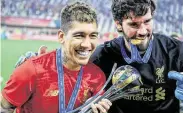  ?? Giuseppe Cacace / AFP via Getty Images ?? Liverpool’s Roberto Firmino, left, and Alisson Becker celebrate after claiming the trophy.