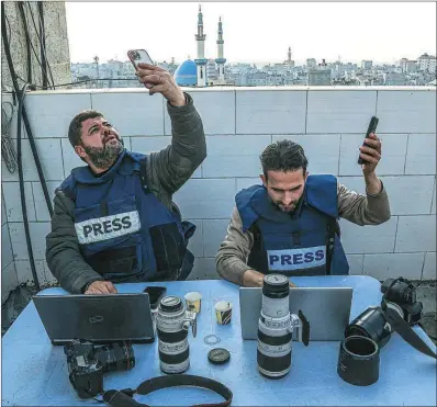  ?? AFP ?? Dos periodista­s comprueban en Rafah la conexión a internet de sus móviles