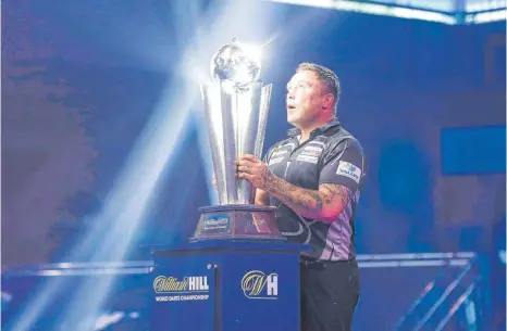  ?? FOTO: SHANE HEALEY/IMAGO IMAGES ?? 25 Kilogramm Trophäe lassen auch einen Dartsweltm­eister kurz in Ehrfurcht verharren: Gerwyn Price mit der Sid-Waddell-Trophy.