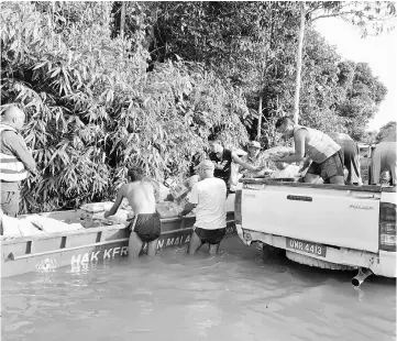  ??  ?? APM personnel conducting the food aid deployment in Rh Akai, Ulu Suai.