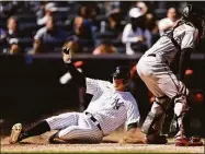  ?? Adam Hunger / Getty Images ?? The Yankees’ DJ LeMahieu scores a run behind Orioles catcher Anthony Bemboom during the fifth inning on Thursday in New York.