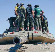  ?? ?? Israeli soldiers work on armored military vehicles at a staging ground near the Israeli-Gaza border, in southern Israel, on Wednesday, May 8, 2024.
