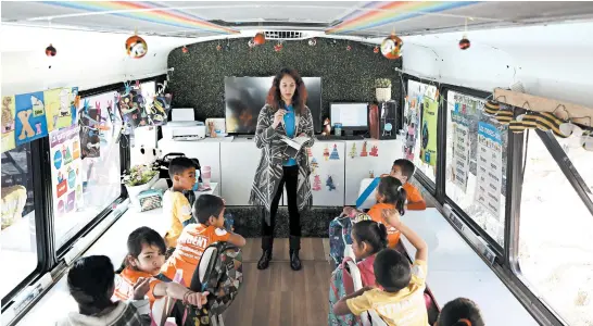  ?? DANIA MAXWELL/LOS ANGELES TIMES PHOTOS ?? Clarissa Ortega leads a class in a converted passenger bus in Tijuana, Mexico. The school is run by a nonprofit that supports children seeking asylum with their families.