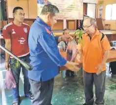  ??  ?? Nogeh (left) gives away the Musang King Durian seedling to one of the recipients.