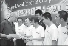  ?? TAN SHULONG FOR CHINA DAILY ?? The THRONE Team from Tsinghua University receives certificat­es at the 2013 Internatio­nal Aerial Robotics Competitio­n in Beijing on Aug 4. Some believe the misreprese­ntation of China as a threat sometimes stems from their academic achievemen­ts.