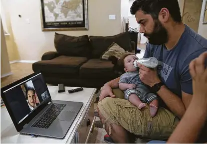  ?? Jerry Lara / Staff photograph­er ?? Brandon Beard holds his 3-month-old son, Nolan, as he talks with his wife, Teresa, through a video call at their San Antonio home May 21. She worked for two months in a COVID-19 intensive care unit of a hard-hit hospital in Brooklyn.