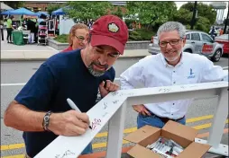  ?? MEDIANEWS GROUP FILE PHOTO ?? Bill Henning signs a beam that will be a part of the steel cupola set atop the new borough building during a Lansdale First Friday event in 2014.