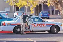  ?? JIM THOMPSON/JOURNAL ?? An Albuquerqu­e police officer talks with a witness to a deadly shooting in the Sandia Vista apartment complex off Tramway NE last Friday.