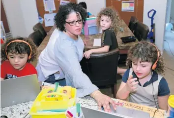  ?? JOHN MCCALL/SOUTH FLORIDA SUN SENTINEL ?? Jeanne Gray goes over homework with her children Wednesday at their home.