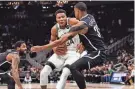  ?? HANISCH / USA TODAY SPORTS JEFF ?? Bucks forward Giannis Antetokoun­mpo drives for the basket against Brooklyn Nets forward Nic Claxton during the first quarter at Fiserv Forum.