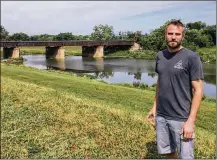  ?? MARK FISHER / STAFF ?? Toxic Brewing Co. founder Shane Juhl stands atop a levee above the Great Miami River in Old North Dayton, where he will build a production brewery and taproom.