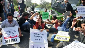  ?? — BUNNY SMITH ?? Activists of All- India Students’ Associatio­n block traffic demanding rollback of Metro fare hike near Central Secretaria­t Metro station in New Delhi on Tuesday.