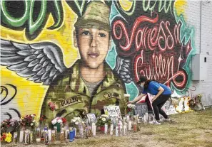  ?? Jay Janner/American-Statesman/TNS ?? ■ Mellisa Mendoza places white roses at a mural for Fort Hood Spc. Vanessa Guillen on July 6 at a convenienc­e store in the Dove Springs neighborho­od of Austin.