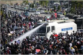  ?? (AP) ?? A police truck uses a water cannon to disperse a crowd of protesters Monday in Naypyitaw, Myanmar, where tensions boiled over after last week’s coup.