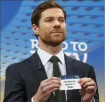  ?? SALVATORE DI NOLFI, THE ASSOCIATED PRESS ?? Former Spanish soccer player Xabi Alonso hold up a Manchester United ticket during the draw of the games for the Champions League Round of 16.