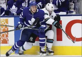  ?? HANS DERYK — THE CANADIAN PRESS VIA AP ?? Tyson Barrie of the Maple Leafs, left, checks the Sharks’ Logan Couture into the boards.