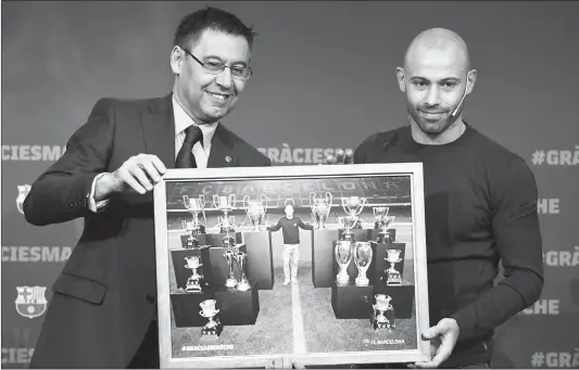  ??  ?? Barcelona FC President Josep Maria Bartomeu (left) and defender Javier Mascherano pose with a framed picture of Mascherano and the major trophies he won with the club during a farewell ceremony in Barcelona ahead of his transfer to China on Wednesday.