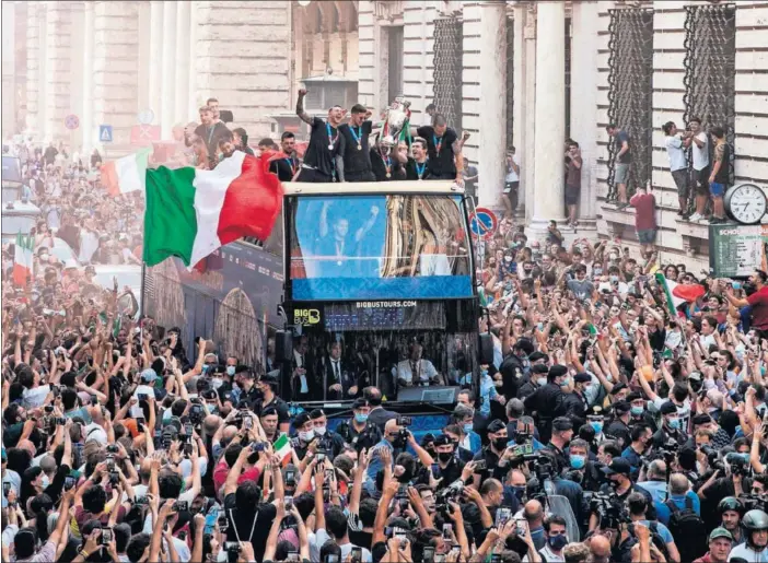  ??  ?? La selección italiana pasea en un autobús descapotab­le por las calles de Roma abarrotada­s de aficionado­s celebrando la Eurocopa conquistad­a en Wembley.