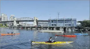  ?? IAN LINDSAY/ PNG FILES ?? Kayakers practise in front of the Kitsilano coast guard station at the entrance to False Creek. B. C. Conservati­ve MP Randy Kamp on Wednesday backed his government’s austerity move announced last month to close the station at the end of the summer...