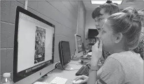  ??  ?? North Point High School freshman Elizabeth Wash, left, helps graphics communicat­ions classmate Gabriella Cross, a freshman, with a design project.